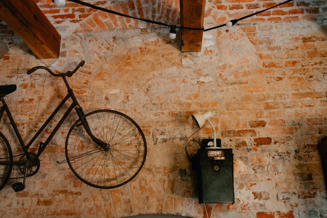 rower powieszonony na scianie z cegły osada młyńska wesele fotograf piotr czyżewski