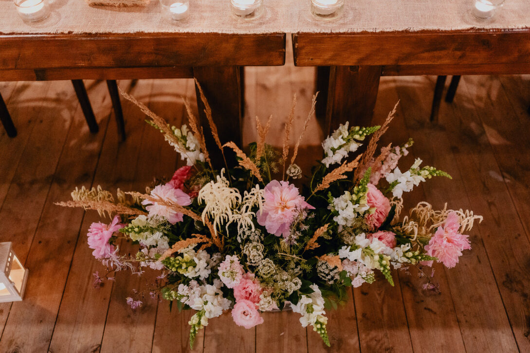 kolorowe kwiaty przed stolem pary mlodej osada młyńska wesele fotograf piotr czyżewski