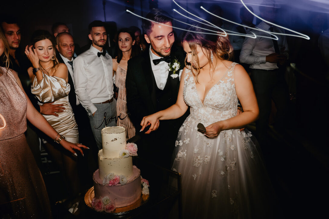 para młoda kroi tort weselny Piotr Czyżewski fotograf na ślub i wesele stara drukarnia